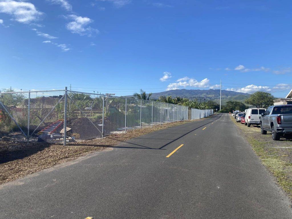 Completed corner section of chain-link fence installation at Kapolei site.