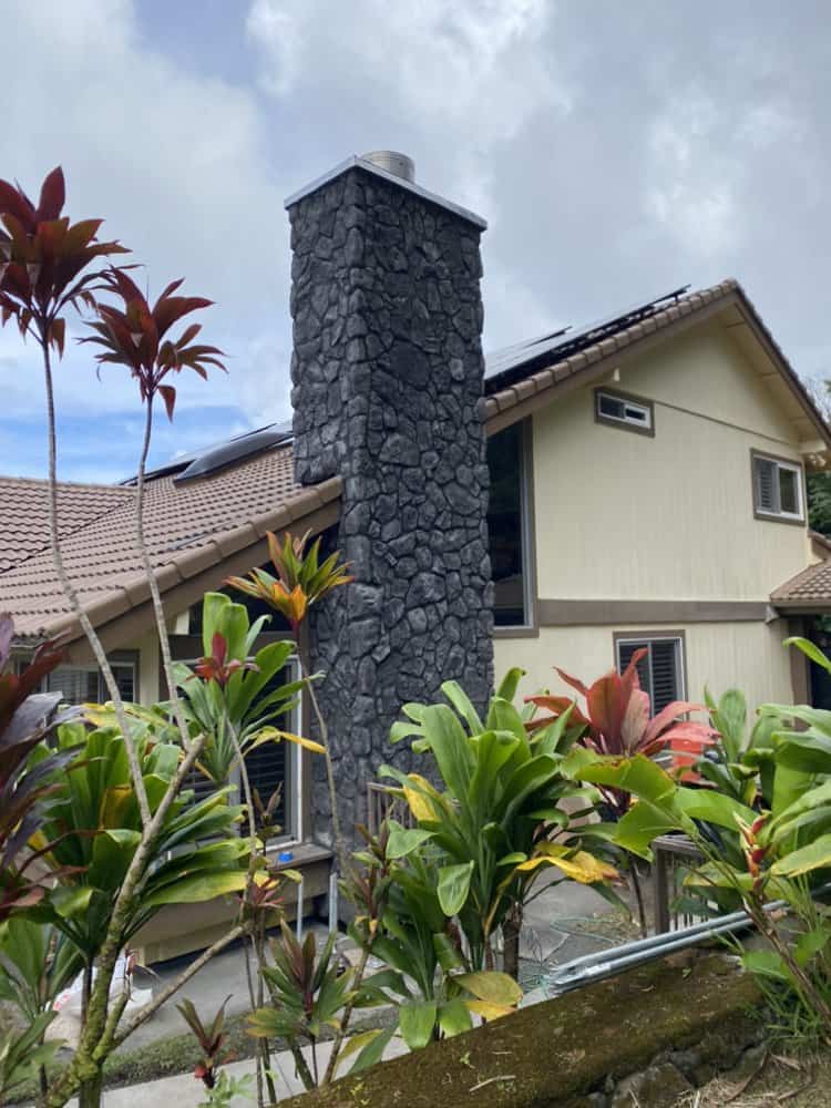 Finished blue rock veneer chimney rebuild with tropical landscaping in Oahu