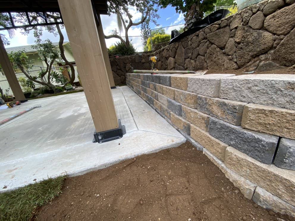 Completed retaining wall installation with clean block layout in an Oahu backyard.