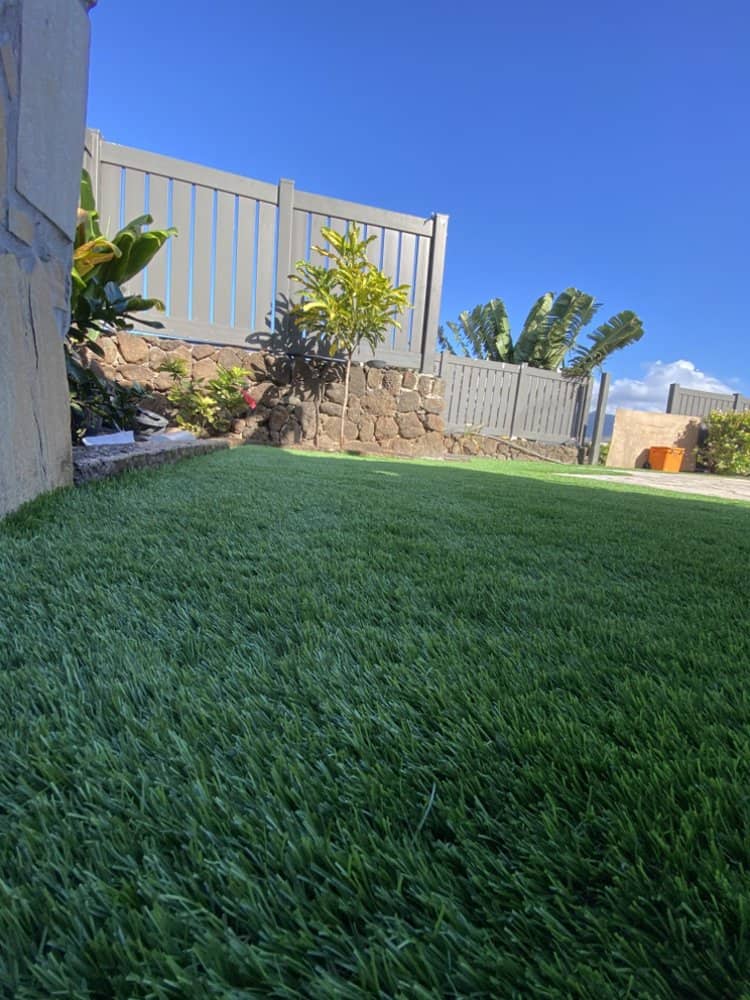 Completed backyard with lush artificial turf and privacy fence in Kapolei.