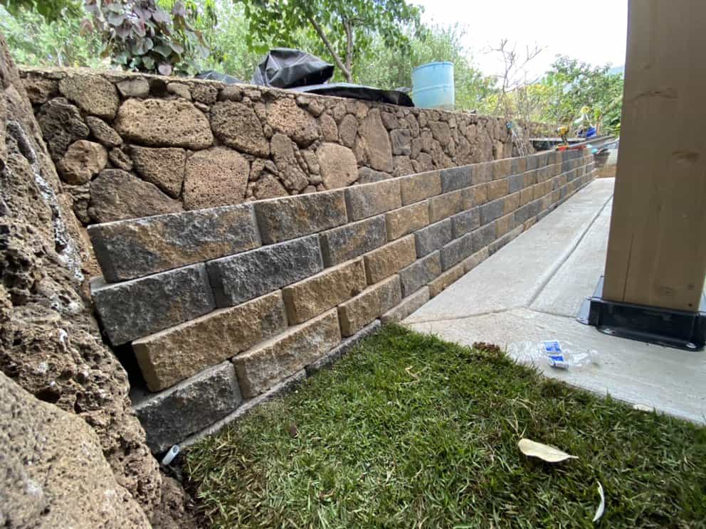 New retaining wall built with block system to stabilize backyard slope.