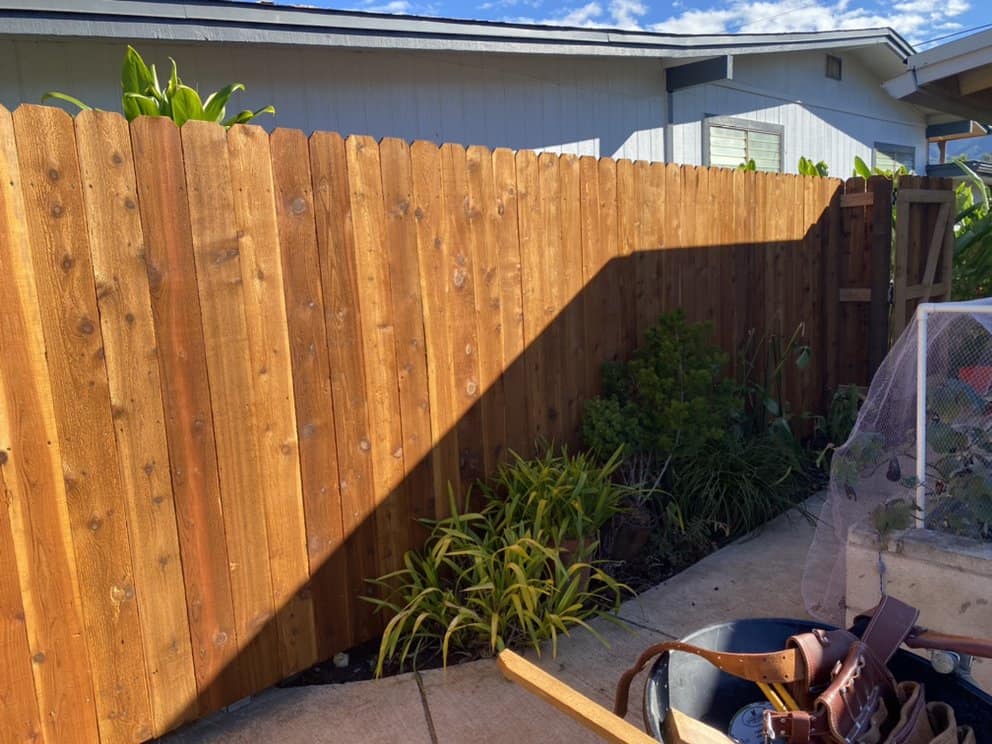 side angle view of newly installed wood privacy fence with clean vertical boards