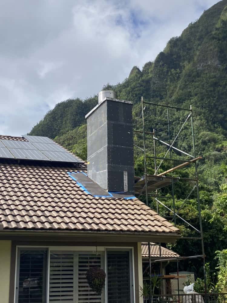 Original damaged chimney structure before rebuild with Koʻolau mountain backdrop
