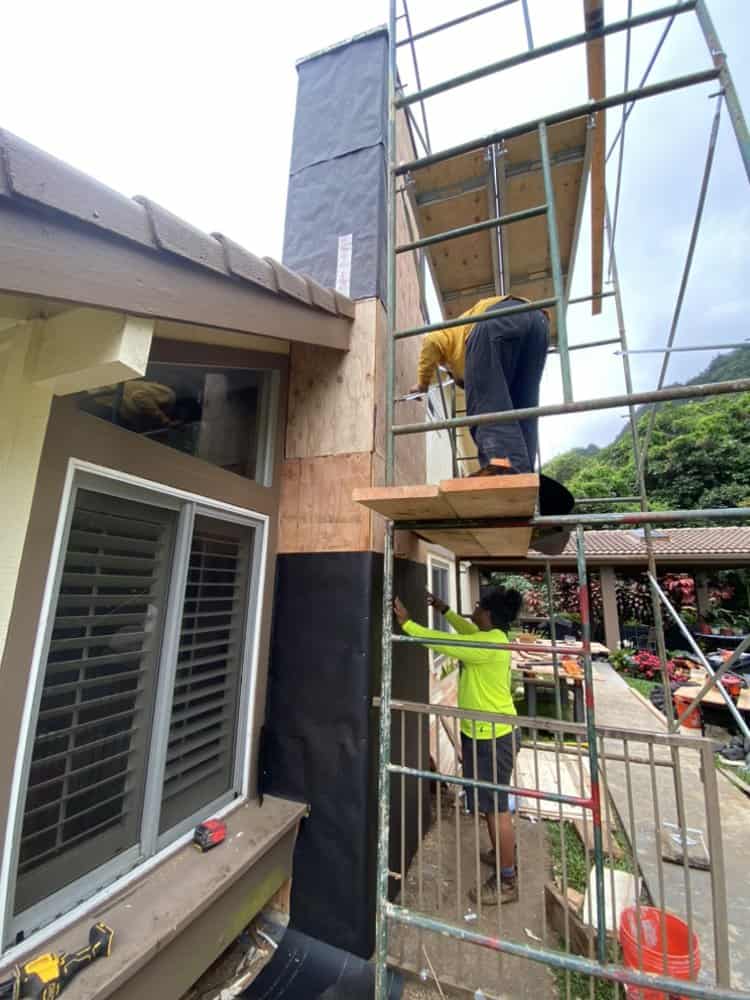 Crew installing metal lath with stainless screws and washers on the chimney structure