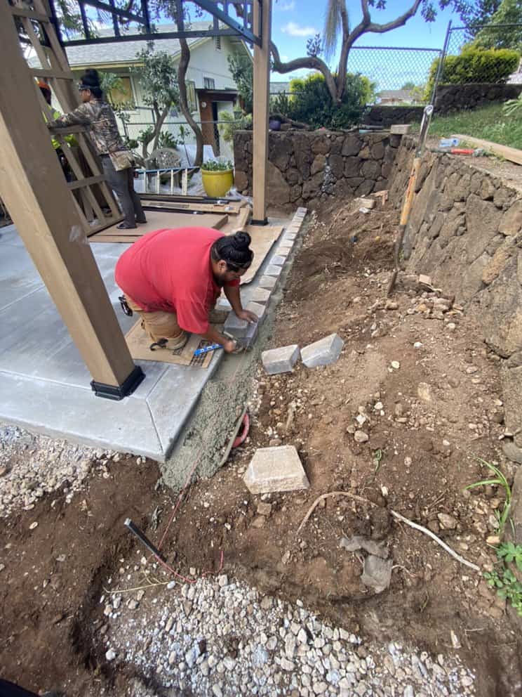Footing trench excavated for retaining wall installation.