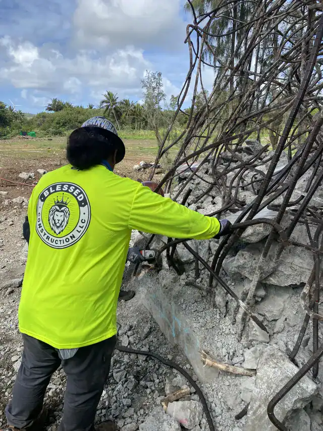 Crew removing exposed rebar from demolished concrete structures.