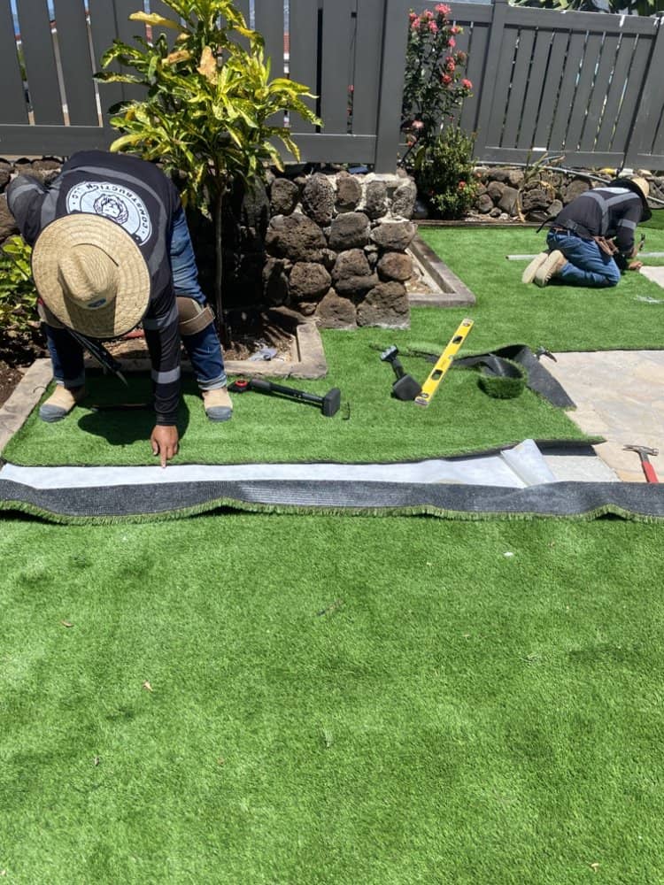Artificial turf panels being set in place during the installation process.