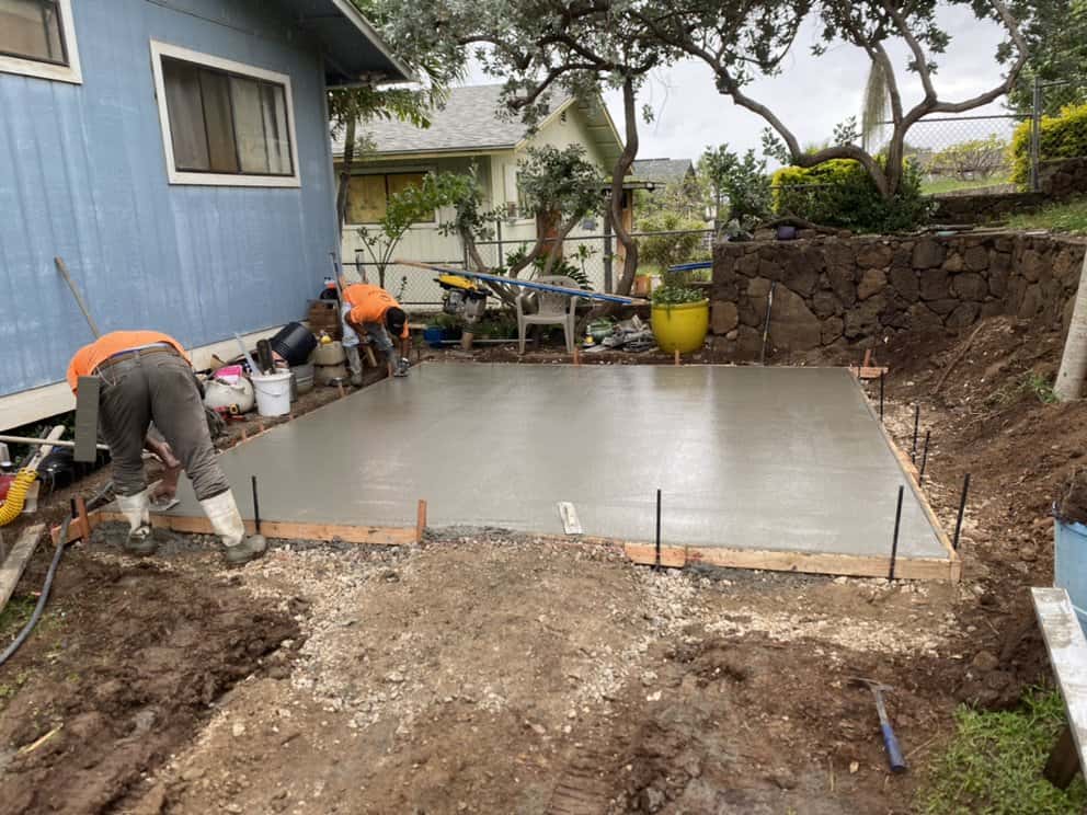 Fresh concrete being poured to create the structural foundation for the outdoor gazebo.