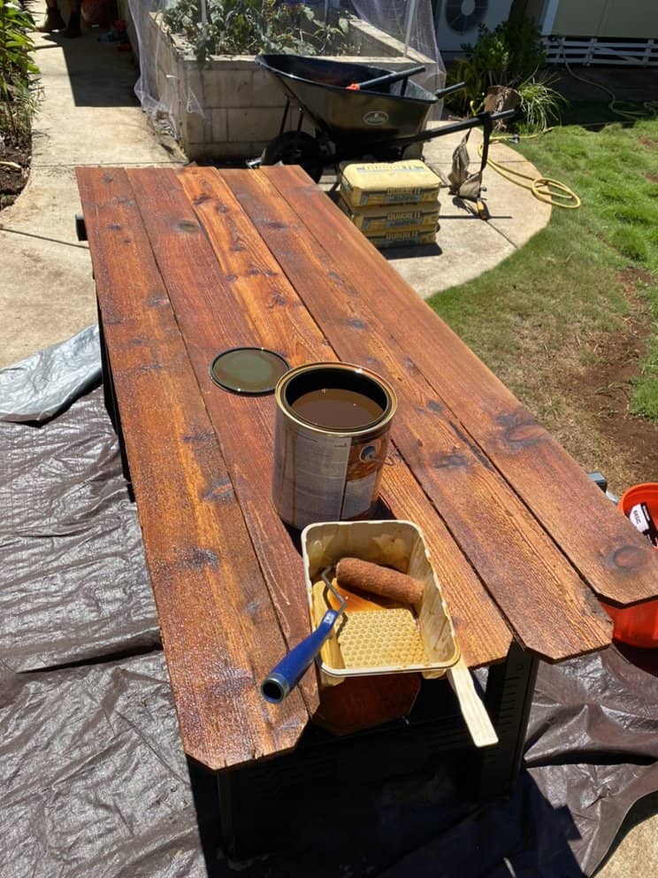 wood fence boards being stained before installation