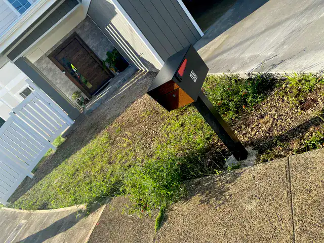 Front yard before installation with uneven soil and weeds in oahu